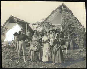 [Família camperola del Delta de l'Ebre fotografiada a l'hort, davant d'un parell de barraques]