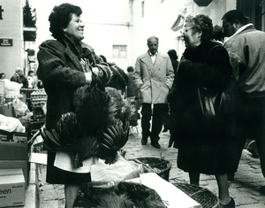 [Primer certamen fotogràfic d’etnografia “Tradició Viva”, 1991 : fira d'aviram, venedora amb dos pollastres]