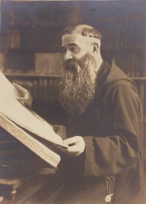 Retrat d'estudi del Pare Miquel A. (Isidre Colldeforns Lladó) llegint a una biblioteca