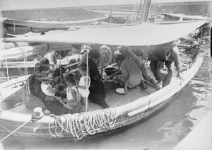 Família de pescadors fent un dinar sota l'envelat d'una barca