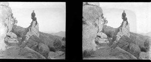 Dos excursionistes asseguts sobre una gran pedra, prop del castell-monestir de Sant Miquel d'Escornalbou