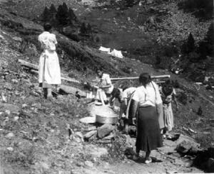 Alumnes de l'Institut-Escola netejant estris de cuina al riu al campament del centre a la Vall Ferrera