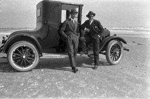 Dos homes davant d'un vehicle aturant a la sorra d'una platja a Galveston, Estats Units