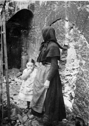 Dona amb una nena entre les runes d'una casa [a Montaragó], al front d'Osca