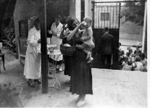 Dones i nens recollint la llet distribuïda pel centre assistencial habilitat a l'Hospital de las Colonias Extranjeras, a Barcelona