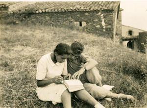 Alumnes de l'Institut-Escola asseguts a la gespa als terrenys de la masia Can Surell estudiant un llibre