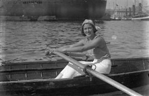 Dona a una embarcació participant a una regata de rem femenina.