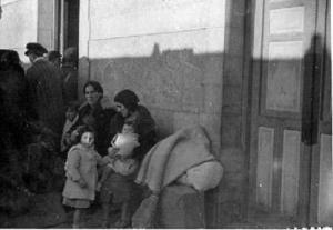 Dones evacuades de Madrid cap a Barcelona, assegudes als bancs d'una estació de ferrocarril amb els seus fills