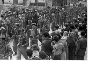 Lluís Companys assistint a una desfilada de combatents republicans pels carrers de [Sariñena] durant la seva visita al front d'Aragó