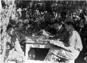 Francesc Josep de Liechtenstein llegint el periòdic amb uns combatents republicans durant la seva visita a un campament, al front d'Aragó