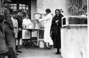 Dones i nens esperant per recollir la llet distribuïda pel centre assistencial habilitat a l'Hospital de las Colonias Extranjeras, a Barcelona
