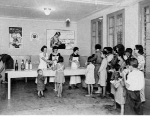 Dones i nens esperant per recollir la llet distribuïda per un centre assistencial dirigit per la Societat dels Amics Quàquers, a Barcelona
